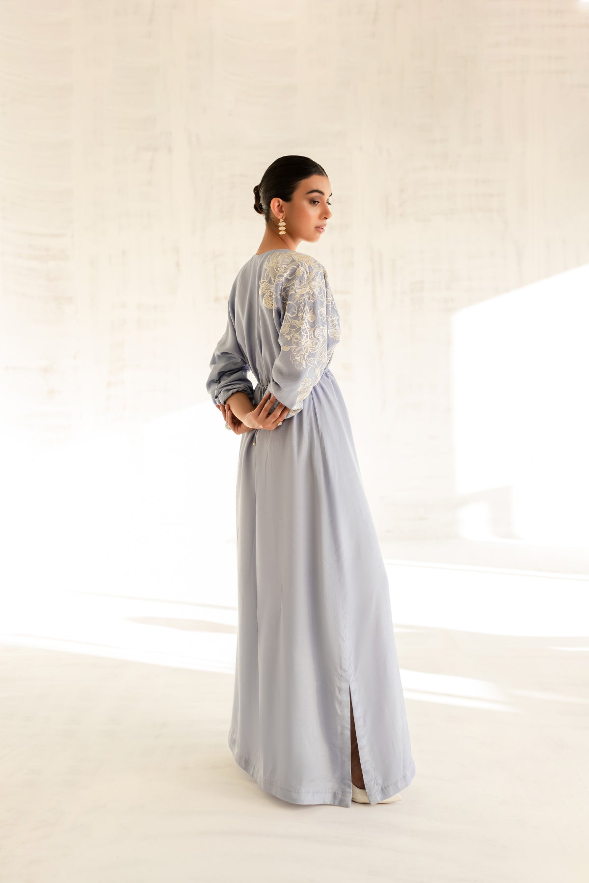 Model in a back side view shot wearing a sky blue embroidered kaftan