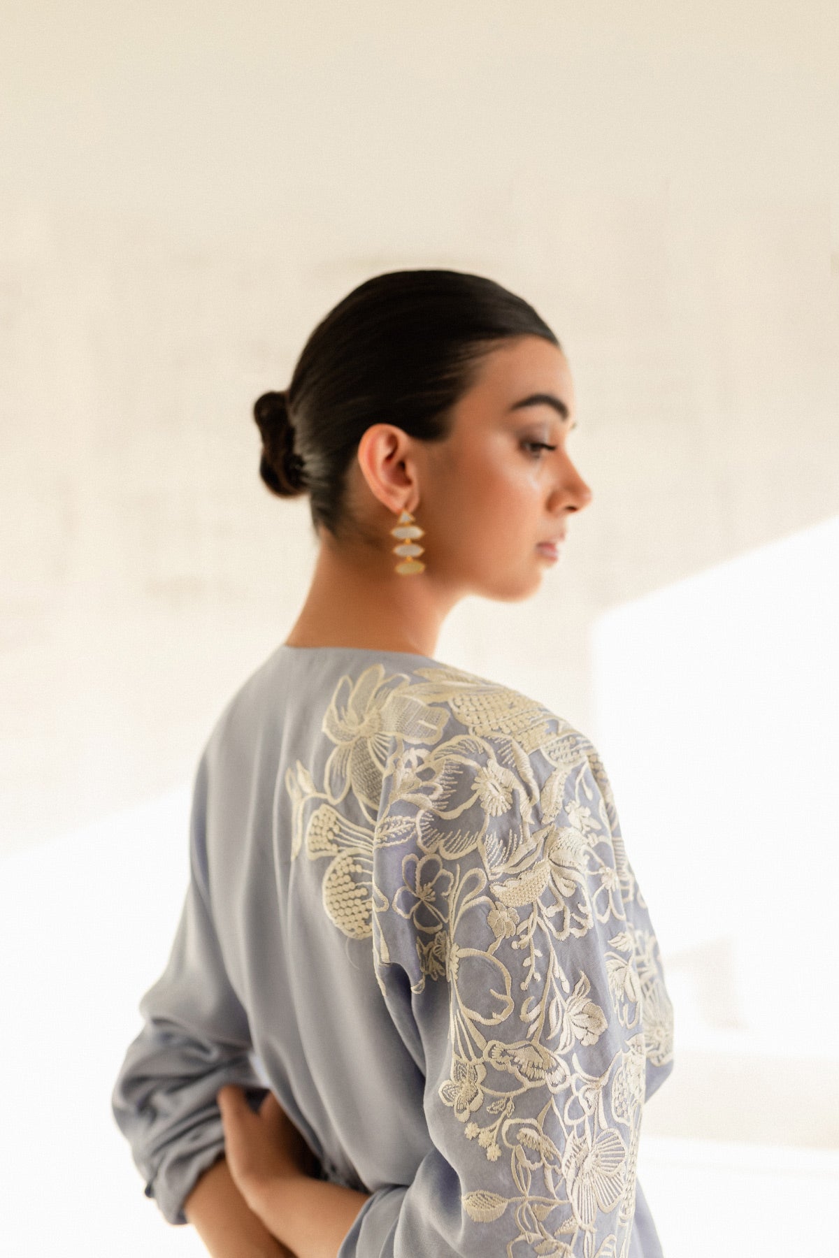 Model in a close-up back view shot wearing a sky blue embroidered kaftan