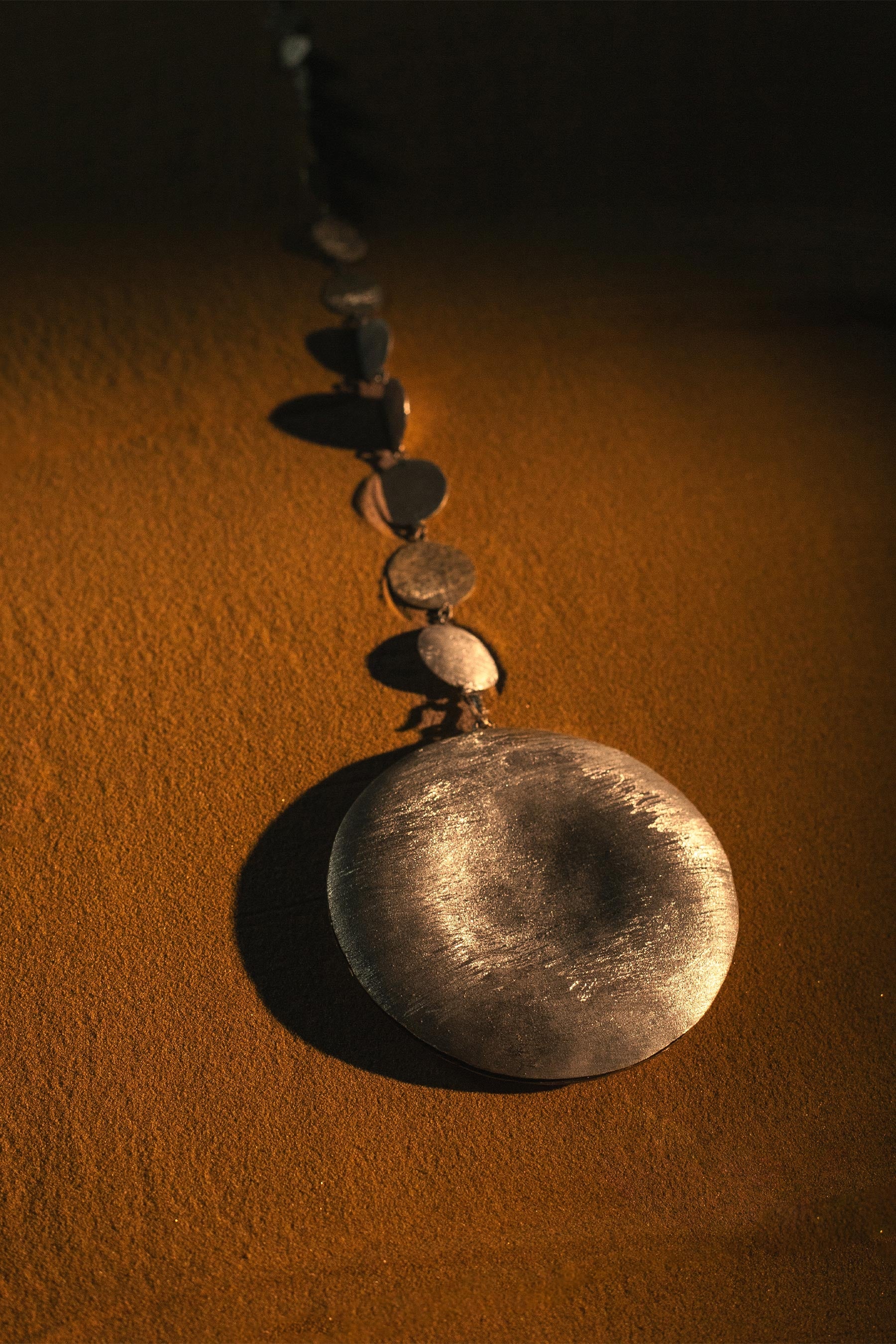 Close up shot of silver tikka on sand