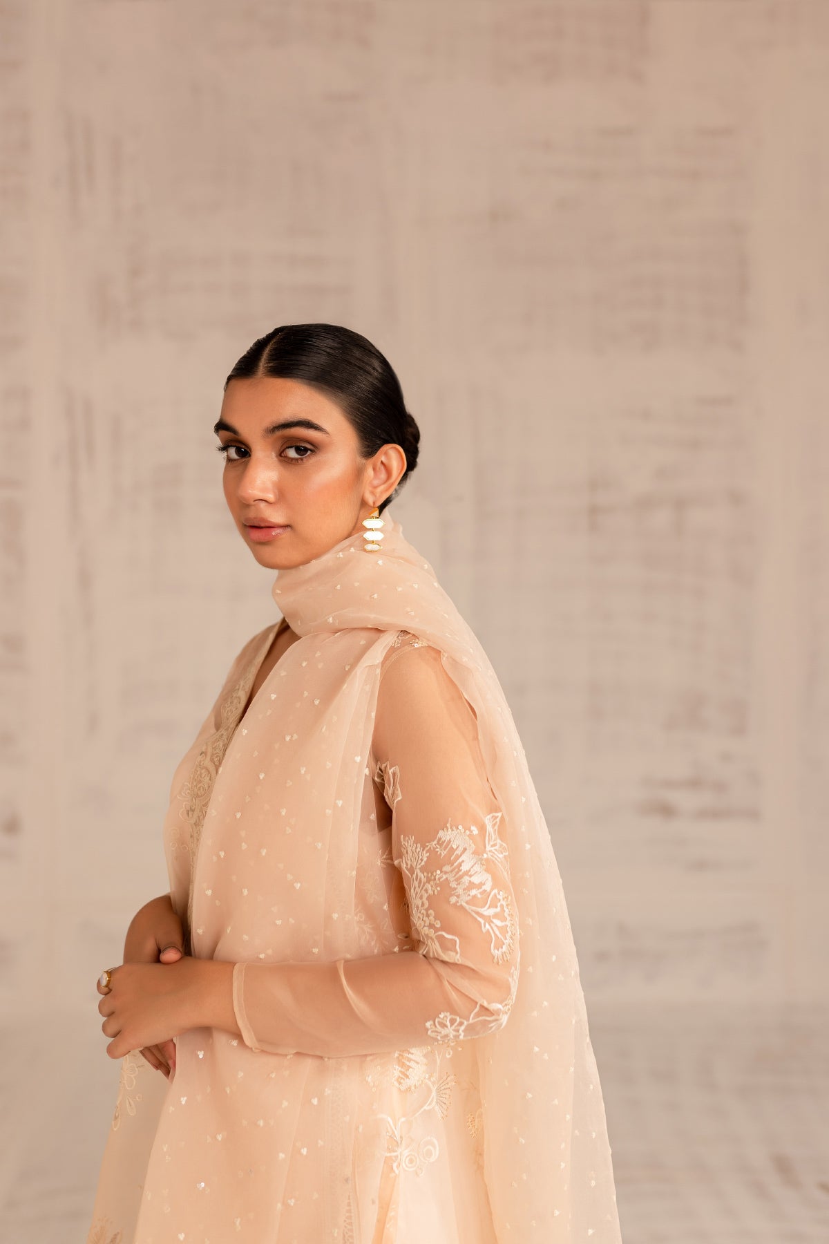 Model in a close-up shot wearing a warm coral organza jacket-styled shirt paired with an organza dupatta