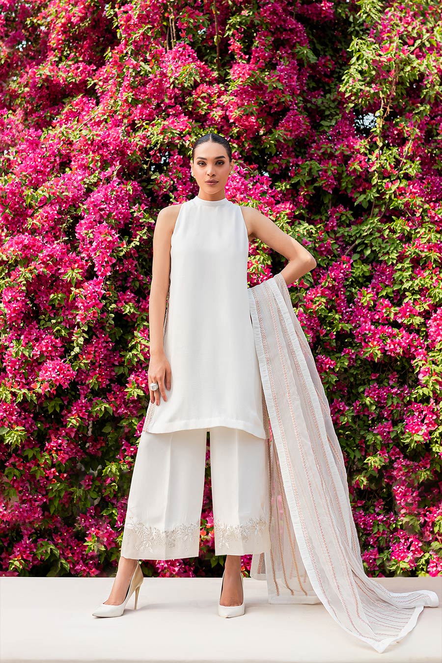 model in a front shot wearing matte silk halter shirt paired with trousers and organza dupatta 