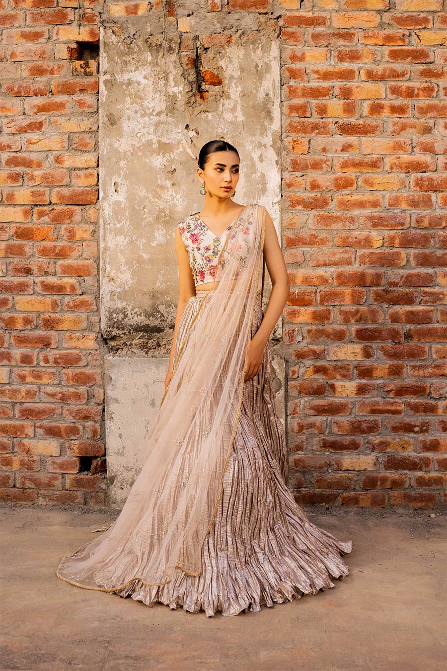 model in a front shot wearing a formal white and rose gold masuri tissueblouse paired with a crushed tissue lehenga and a net embellished drape