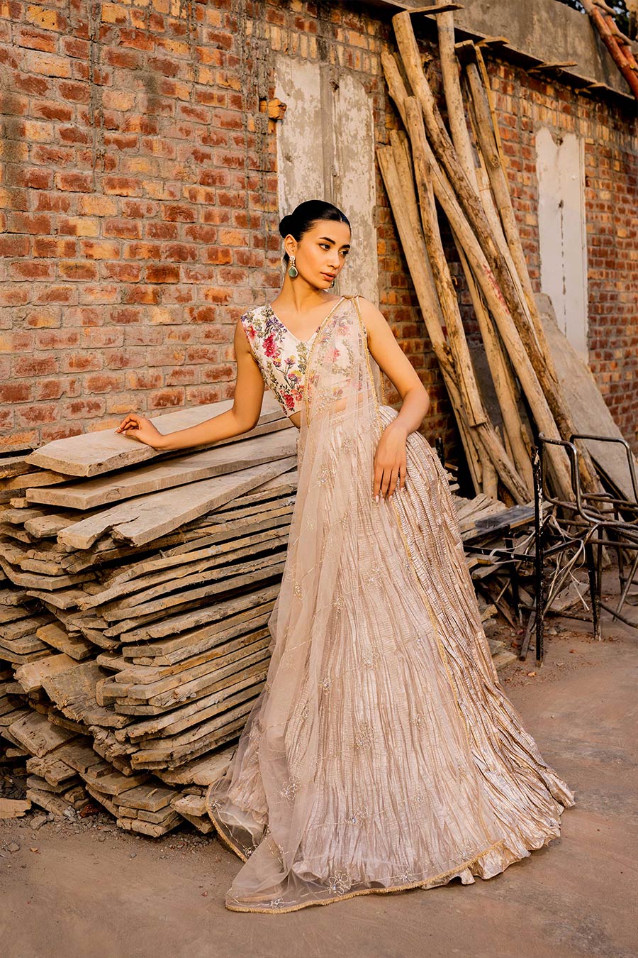 model in a front shot wearing a formal white and rose gold masuri tissueblouse paired with a crushed tissue lehenga and a net embellished drape