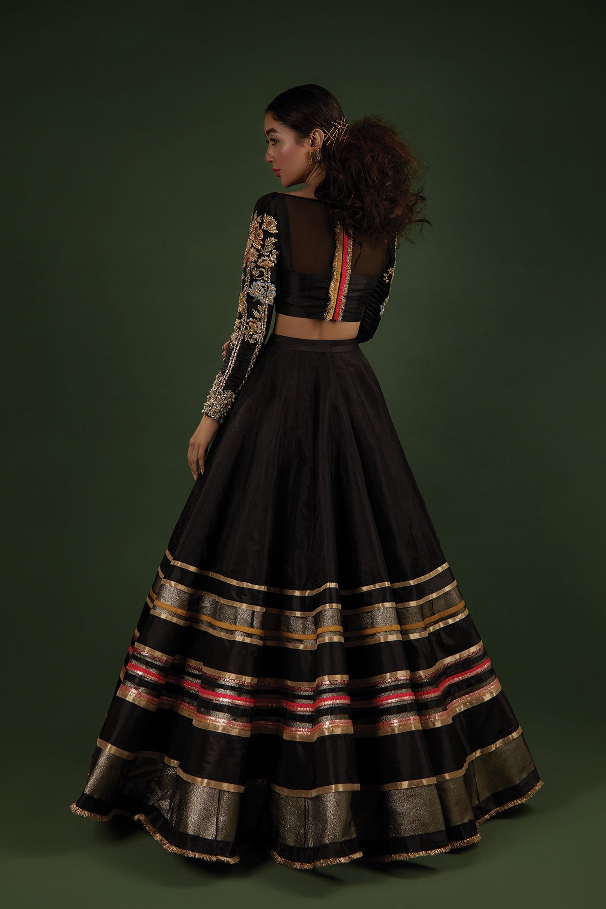 Model in a back shot wearing black lehenga choli made of katan silk paired with a black lehenga 