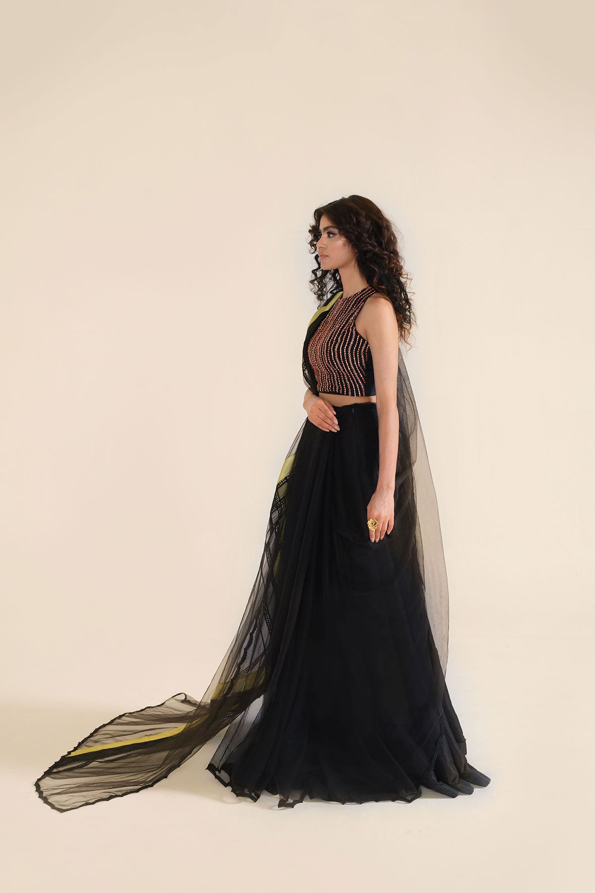 Model in a seated top shot wearing black formal lehenga saree paired with lehenga 