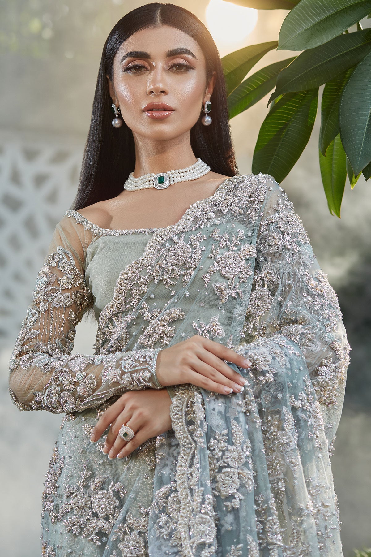 model in a closeup shot wearing blue bridal saree with net blouse and silk brocade lehenga