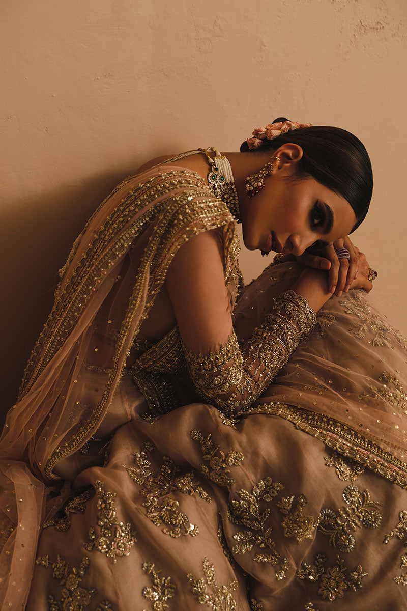 Rabia Butt in a seated closeup shot wearing blush pink silk organza lehenga choli accompanied by a net dupatta 