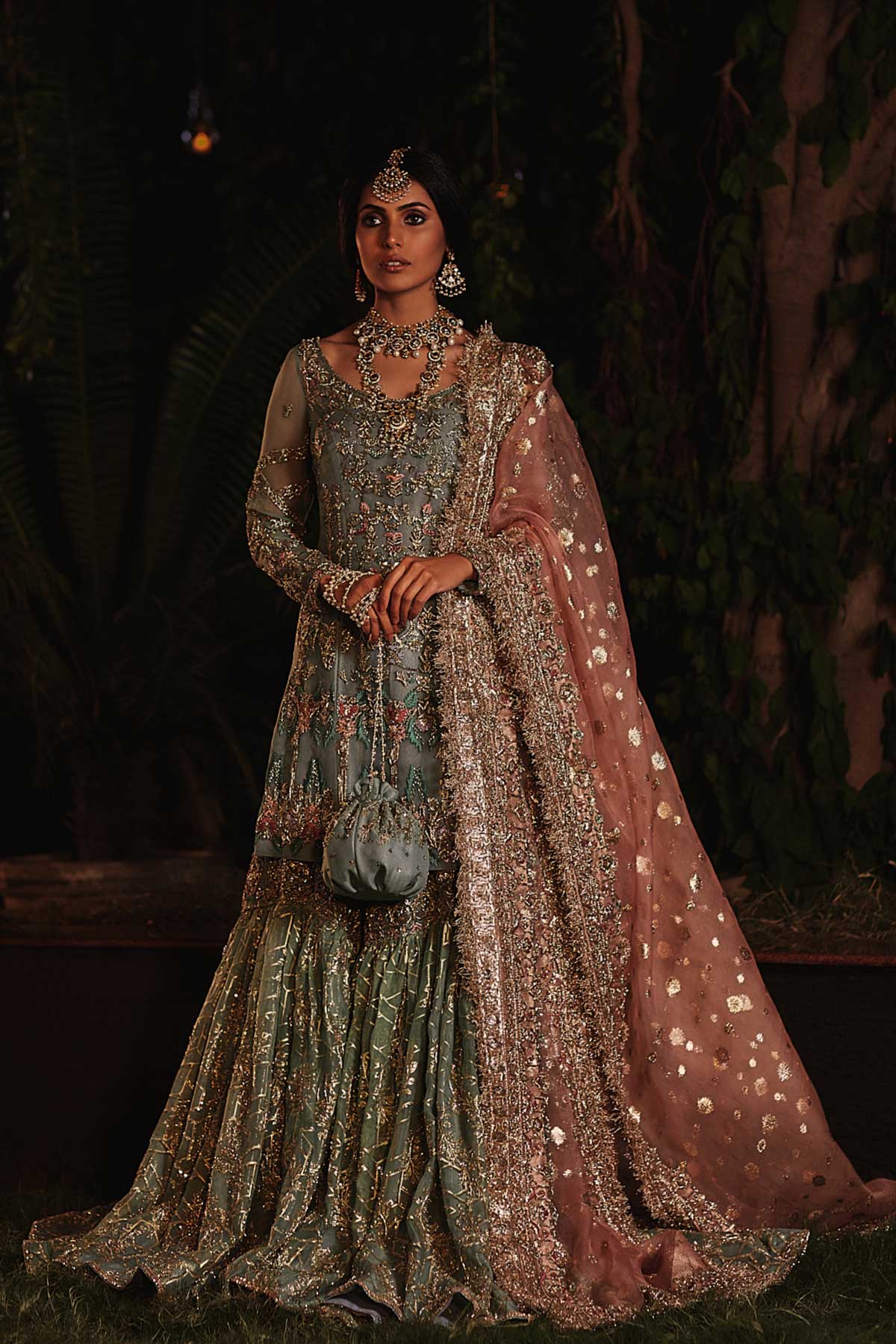 model in a front shot wearing straight silk organza shirt in dusty blue color paired with silk organza gharara and organza zari dupatta 