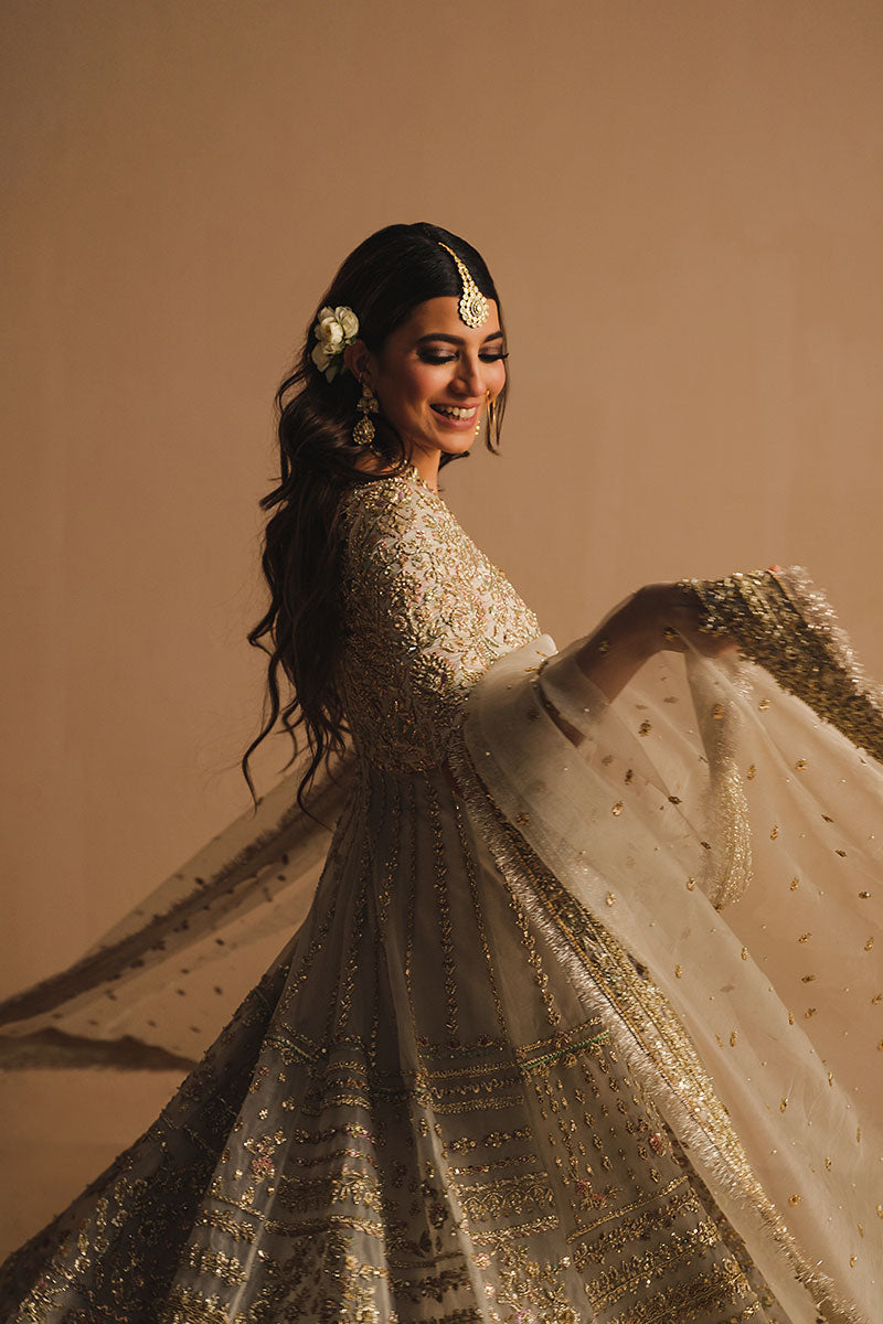 Rabia Butt in side view closeup shot wearing white net pishwas paired with a net lehenga and organza net dupatta