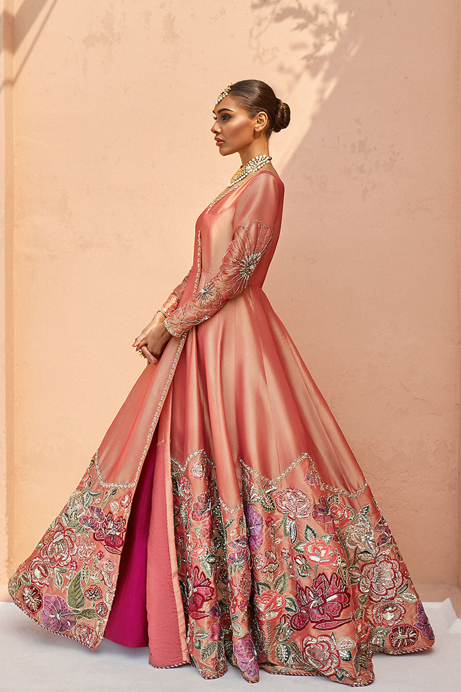 model in a side shot wearing formal double-toned silk kattan angrakha paired with a fuchsia kattan lehenga.