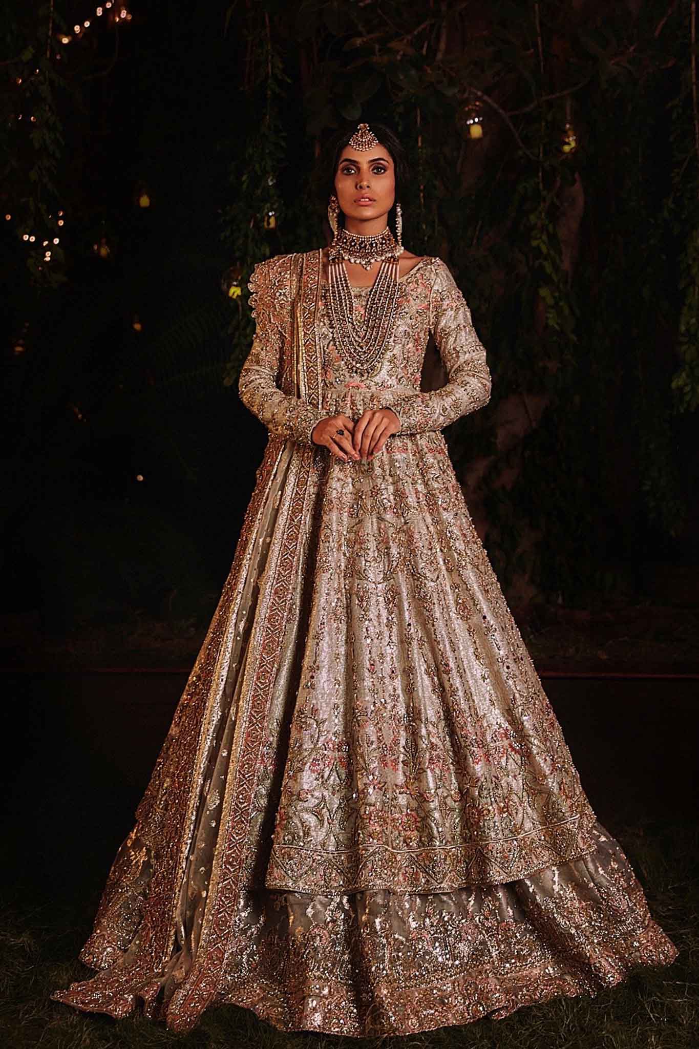 model in a front shot wearing ivory bridal silk brocade pishwas, with a lilac lehenga and an ivory dupatta