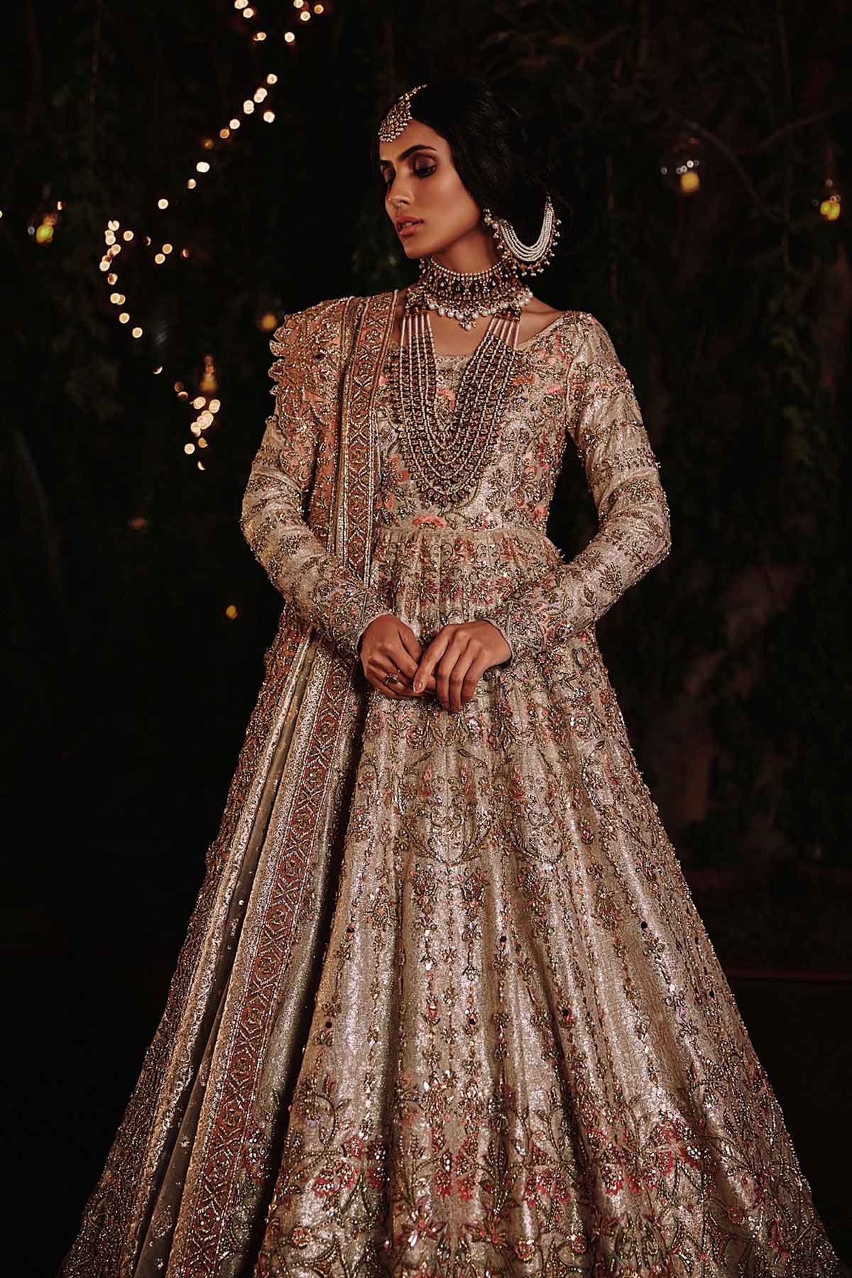 model in a front shot wearing ivory bridal silk brocade pishwas, with a lilac lehenga and an ivory dupatta