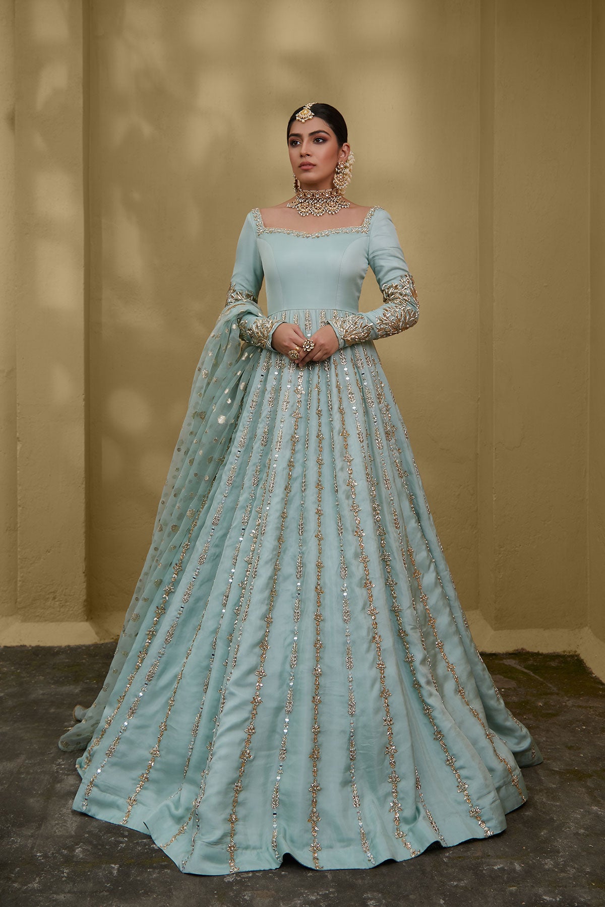 Model in a front shot wearing a formal light blue gown made of silk chiffon fabric paired with a blue organza zari dupatta