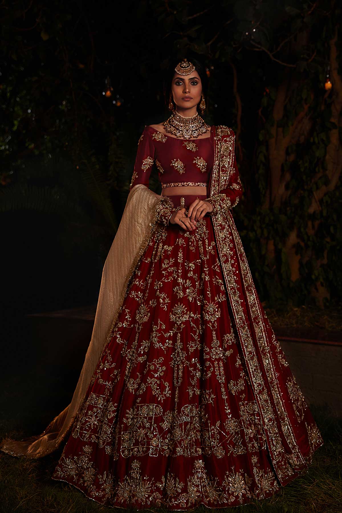 model in a front shot wearing red bridal lehenga choli in raw silk fabric paired with silk organza dupatta