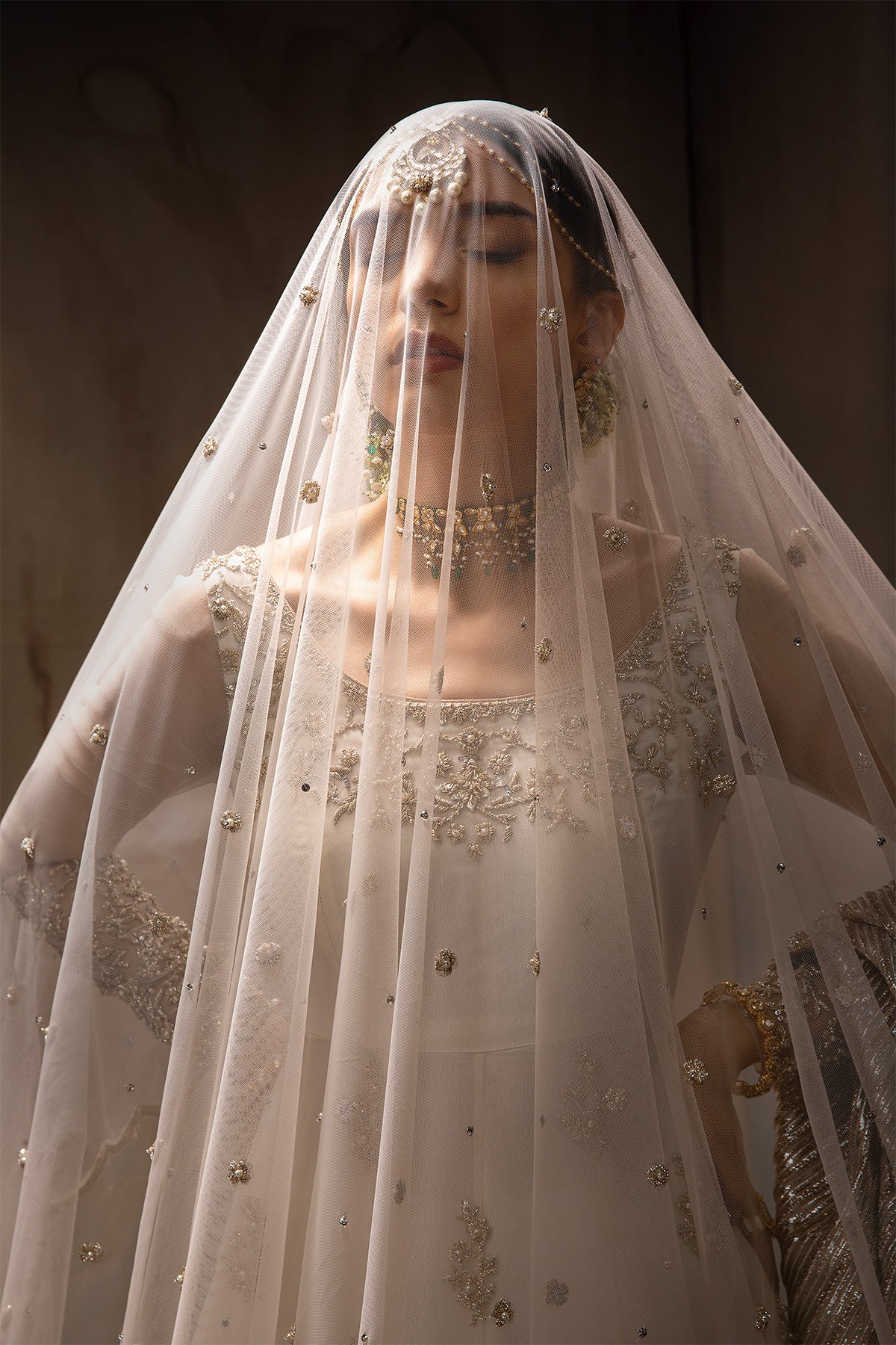 Model in a front closeup shot wearing white long pishwas gown paired net dupatta