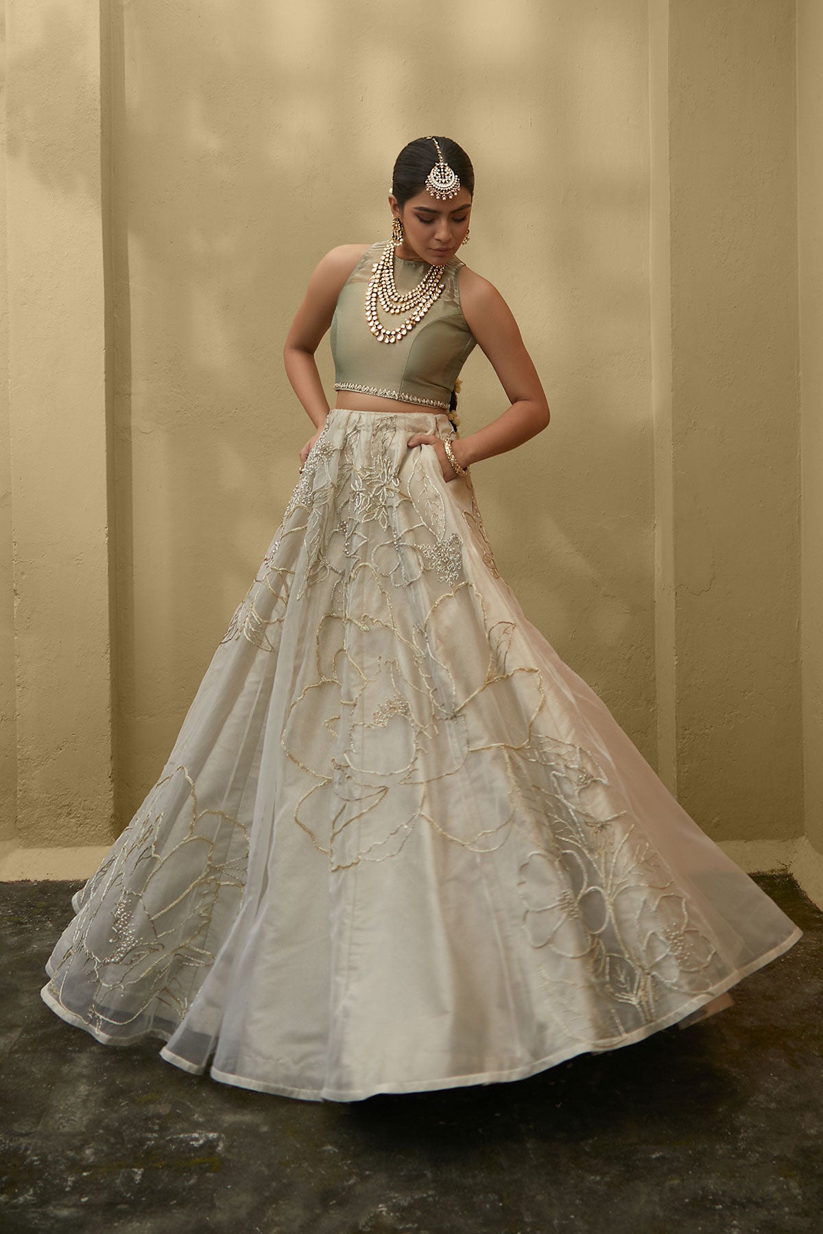 Model in a front shot wearing white organza skirt paired with green tissue blouse and an embroidered tissue dupatta